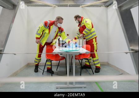 01 December 2020, Hessen, Eschwege: The two emergency paramedics Matthias Gebhardt (l) and Mathias Haas unpack a diagnostic bag in the sports hall of the upper secondary school. In Eschwege in the Werra-Meissner district, a vaccination centre is set up by the district and various disaster control organisations. Photo: Swen Pförtner/dpa Stock Photo