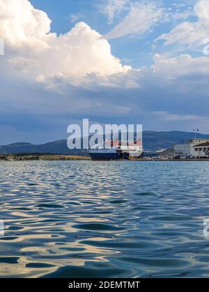 Big white ship. Ferry for passengers and vehicles. Loading cars and boarding people on ship at the port of Volos, Greece Stock Photo