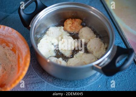 homemade cakes in a pan, fry sweet cheesecakes for tea, boiling oil Stock Photo