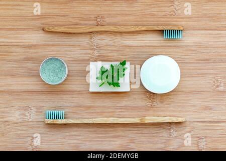 Zero waste bathroom basics. Bamboo toothbrushes,  solid toothpaste in metal tin, solid shampoo and soap on wood background. Plastic free, environment Stock Photo
