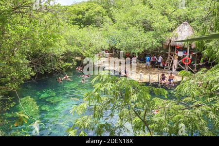 TULUM, MEXICO - Jul 29, 2019: Swimmers enjoy the clear warm waters of Cenote Cristalino. Stock Photo