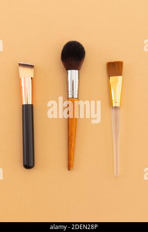 High angle view of three makeup brushes on yellow background Stock Photo