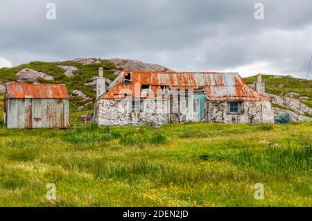 A dilapidated old croft building at Cuidhtinis in the Bays area of South Harris in the Outer Hebrides. Stock Photo