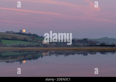 Moonrise and pink sunset sky over River Torridge near Bideford. Devon, England. November. Stock Photo
