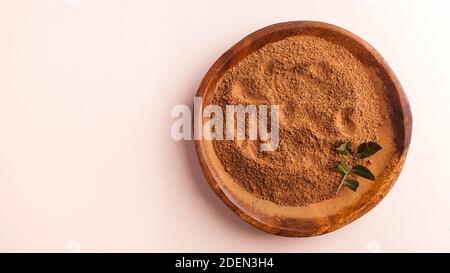 Cocoa powder in a wooden bowl on a pink background. Cocoa product. Copy space. Stock Photo