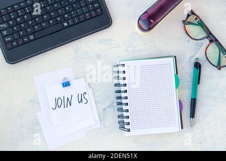 Join us. Job recruiting concept. Words Join us in sticker on the working table. Top view. Stock Photo