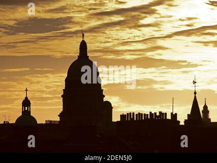 City centre, Edinburgh, Scotland, UK. 1 December 2020. A moody sky towards sunset highlighting the architecture of the old town. Pictured: Golden Boy statue on the dome of Edinburgh University's Old College and left the dome with cross on St Patrick's Church a Roman Catholic Parish church in the Cowgate. Credit: Arch White/Alamy Live News Stock Photo