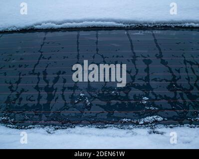 Melting snow on the car window glass. Car window glass. Snow melting. Water drops. Winter period. Frosty frost. Frozen water. Vehicle. Caring for a ve Stock Photo