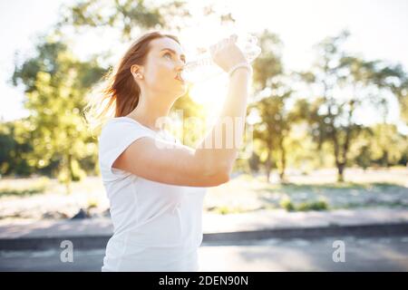 Young sports girl, drinking water from the bottle, after a hard workout, can be used for advertising, Stock Photo