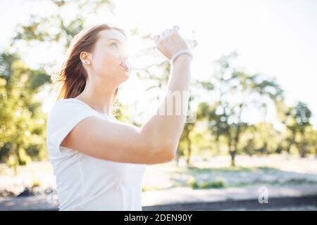 Young sports girl, drinking water from the bottle, after a hard workout, can be used for advertising, Stock Photo
