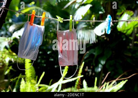 masks hanging from a clothesline after being washed. Covid-19 virus and coronavirus pandemic context Stock Photo