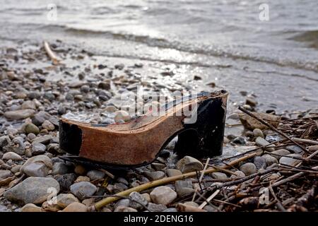 broken shoe of which only the wooden sole is left, lying on the beach Stock Photo