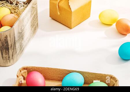 Easter eggs in the sunlight on the white table near the window. Bright spring Easter background Stock Photo