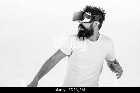 Man with beard in VR glasses run away , white background. VR game concept. Guy with head mounted display run in virtual reality. Hipster on scared face exploring virtual reality with modern gadget. Stock Photo
