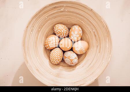 Minimalistic composition. Easter eggs on a plate. Eco style. Warm pastel tones. View from above Stock Photo