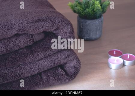Winter blanket on a wooden table. Clothes with different patterns of fabric folded in pile. Winter bedding. Stock Photo