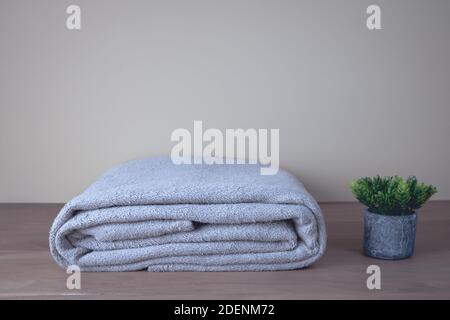 Winter blanket on a wooden table. Clothes with different patterns of fabric folded in pile. Winter bedding. Stock Photo