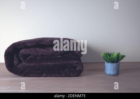 Winter blanket on a wooden table. Clothes with different patterns of fabric folded in pile. Winter bedding. Stock Photo