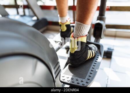 feet close-up, man riding a sports bike in the gym, morning training Stock Photo