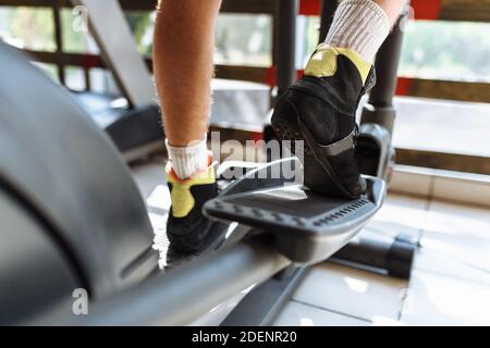 feet close-up, man riding a sports bike in the gym, morning training Stock Photo