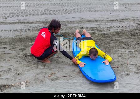 A Filipino man learning surfing in Baler, Philippines Stock Photo