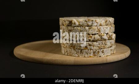 Grain crispbreads crispy rice and diet bread. Stack of puffed whole grain crispbread. Rice cake puffed rice on black background Stock Photo