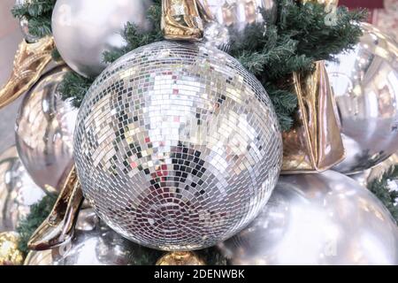 Mirror disco ball and gold shoes on the Christmas tree. Stock Photo