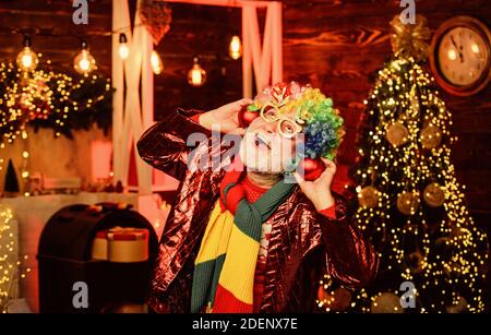 having fun. xmas gifts. Time for presents. christmas tree decoration. Going crazy. happy man with beard. mature bearded freak. party man in clown wig. Stock Photo