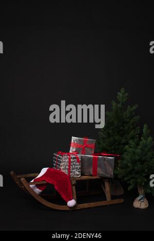 Rustic sleigh with gift boxes next to Christmas tree Stock Photo