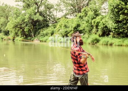 Born to Fish. hobby and sport activity. pothunter. bearded fisher in water. mature man fly fishing. man catching fish. summer weekend. Big game fishin Stock Photo