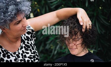 Stock photo of young woman getting her haircut. She has short and curly hair. Stock Photo