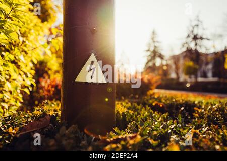 high voltage sign on a pole in the park Stock Photo