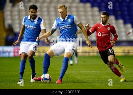 Birmingham City's Kristian Pedersen and Barnsley's Conor Chaplin (right) battle for the ball during the Sky Bet Championship match at the St. Andrew's Trillion Trophy Stadium, Birmingham. Stock Photo
