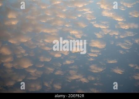 Golden hour sunlight on the sky reflected in a tranquil lake. Stock Photo