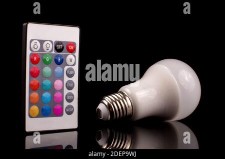 Remote control for light emitting diode LED theme light bulb isolated on the black background Stock Photo