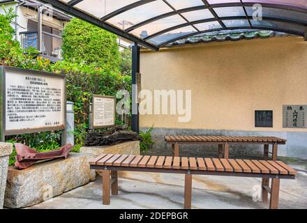 tokyo, japan - november 25 2020: Rest area of Buddhist Tamonji temple with benches in front of Information signboards on the history of ruins of steel Stock Photo