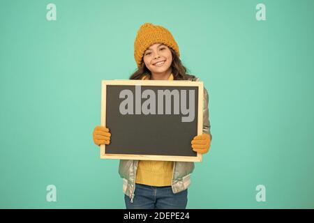 Open hours. Winter entertainment and activities. Happy hours. Promotion concept. Smiling girl wear winter outfit show blank chalkboard copy space. Fresh information. Schedule and working hours. Stock Photo