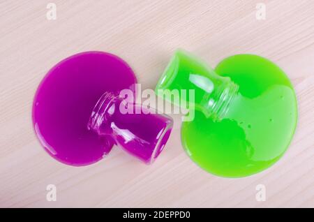 Bright multi colored slimes on a table. Kids most popular toy of nowadays. Slime in plastic containers. Stock Photo