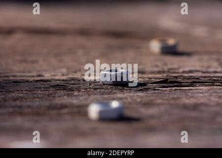 Three old metal nuts in a macro shot and only one of them in focus by the short deep of field used. Stock Photo