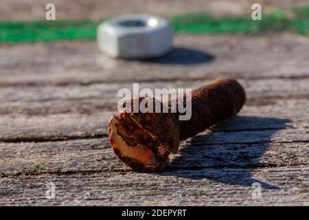 old rusty screw on a old wooden table Stock Photo
