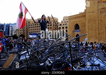 A demonstrator stand on the remains of the tents that were Destroyed tents by pro-Iranian Hezbollah supporters who attacked protestors in Martyr square on the 13th day of consecutive protests. Prime Minister Saad al-Hariri submits his resignation after an address to the nation. Beirut, Lebanon, on October 29, 2019. Photo by Alfred Yaghobzadeh/ABACAPRESS.COM Stock Photo