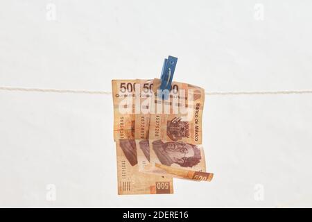 Mexican currency on a rope isolated on white background