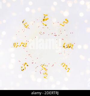 Frame with golden decorations, confetti, sparkles, lights on white background. Christmas, New year, party, wedding, birthday Flay lay copy space Stock Photo