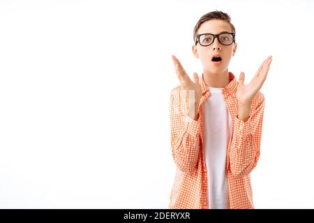 The young man shocked by the news, the teenager with the glasses raised his hands up in Studio on white background Stock Photo