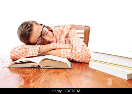 teen guy fell asleep sitting with books, student sleeping at Desk in Studio Stock Photo