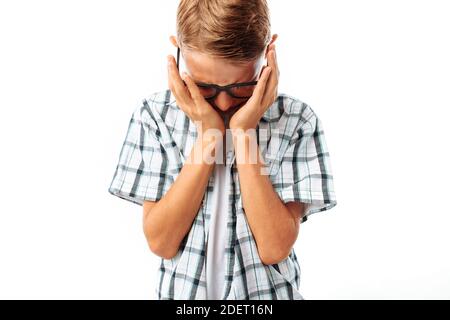 Teen boy than the upset wipes his hand tears, frustration after school, in the Studio Stock Photo