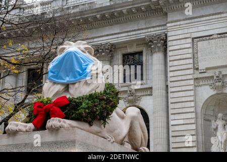 Lion in front of the New York Public Library wears a face mask and Holiday Wreath  during the coronavirus pandemic, NYC