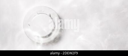 Smoke detector mounted on roof in apartment Stock Photo