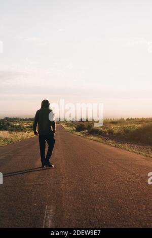 young man walking on street at sunrise Stock Photo