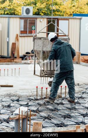 Construction worker using safety rules is working on a reinforced concrete slab pouring concrete Stock Photo